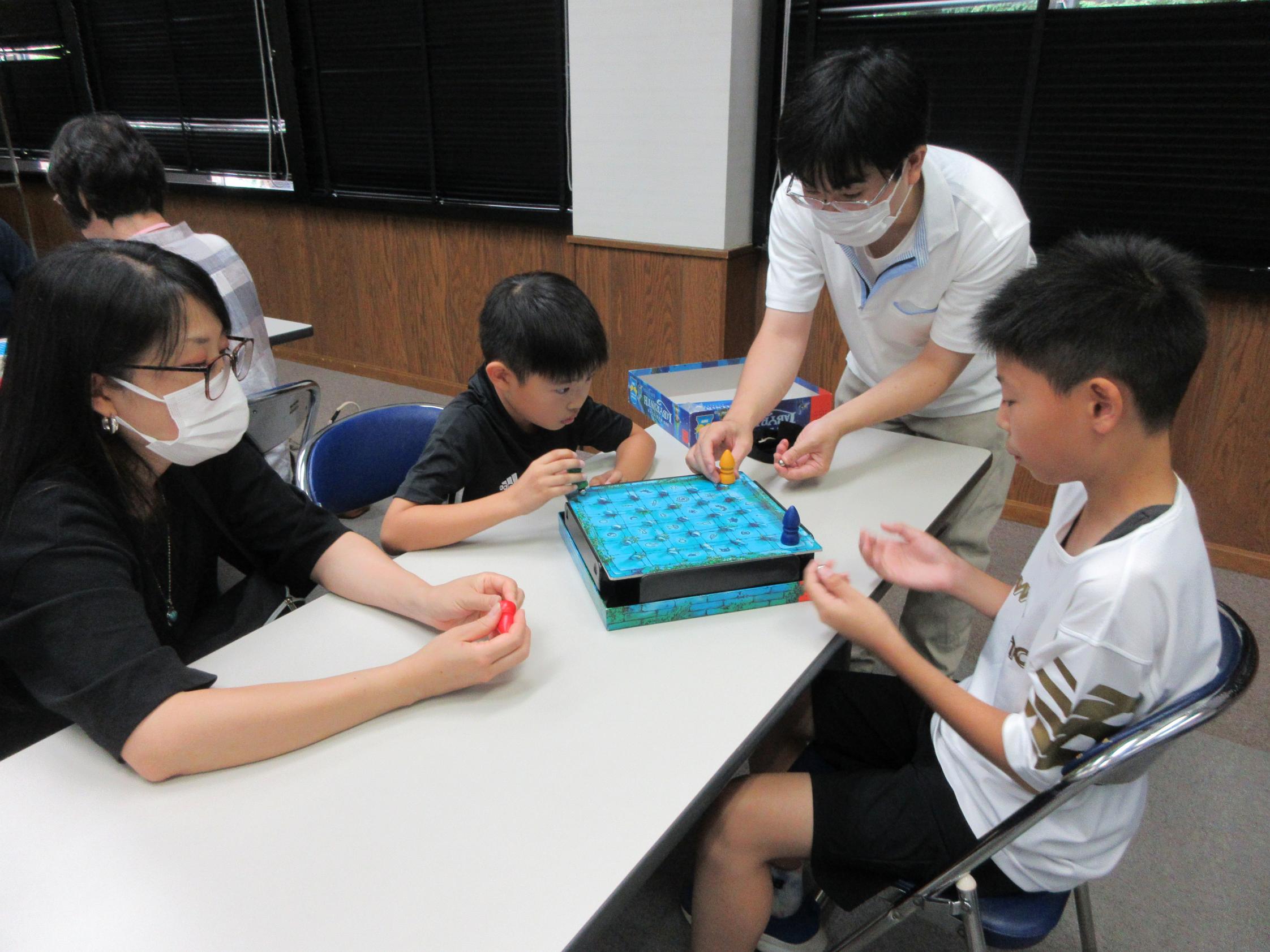 講師の先生に教えてもらってボードゲームをしている様子 講師の先生に教えてもらってボードゲームをしている様子